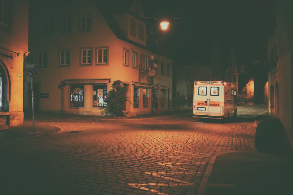 weißer und orangener Bus auf der Straße während der Nachtzeit